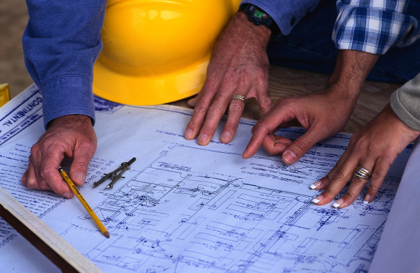 Hands of Couple Looking at Blueprints